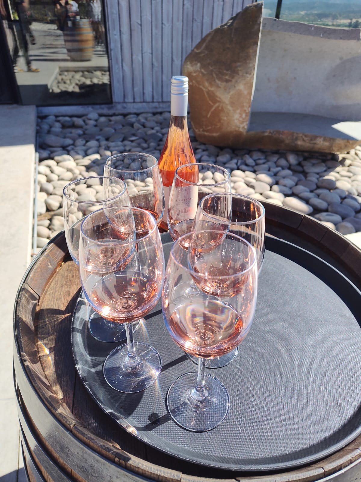 Copas con vino rosado dispuestas sobre una barrica durante una degustación