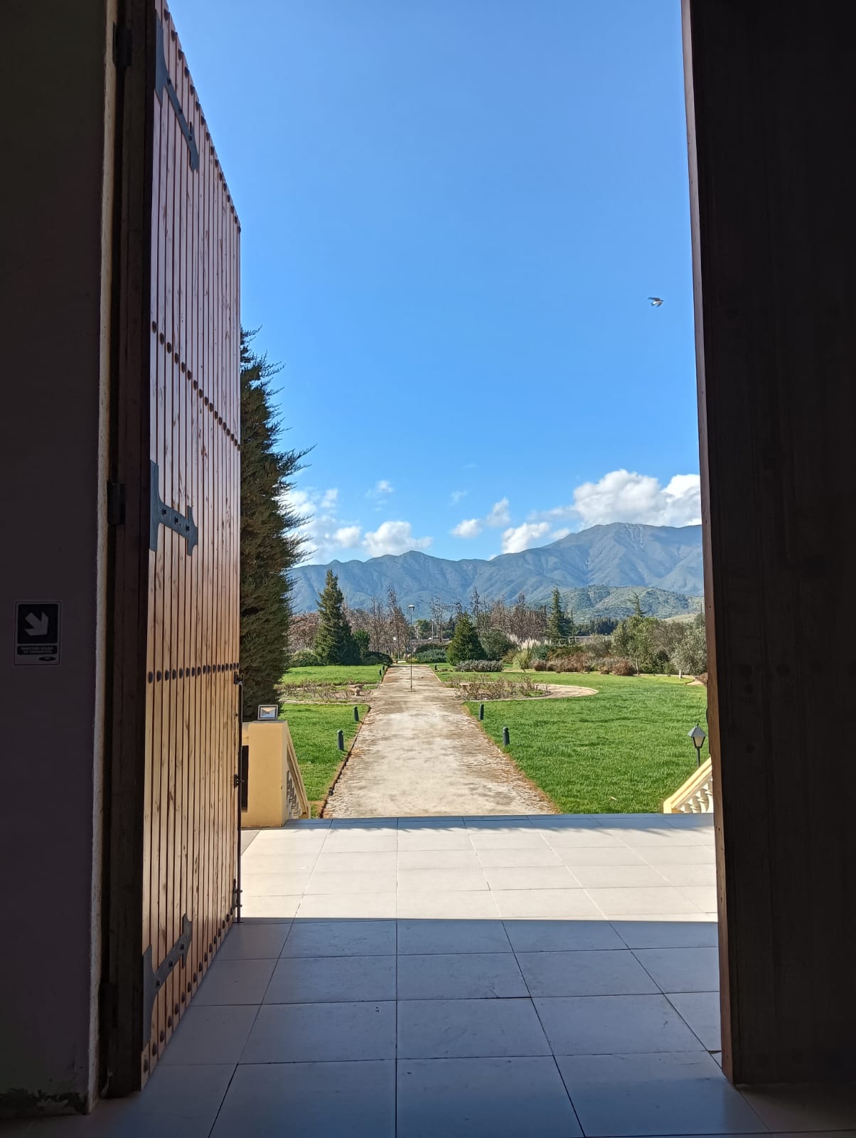 Vista hacia jardines y montañas desde la entrada de una viña